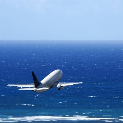 <img scr=” Airplane over ocean.jpg” alt=”Take a family vacation by air, Omaha, Enchanted Honeymoons”>
